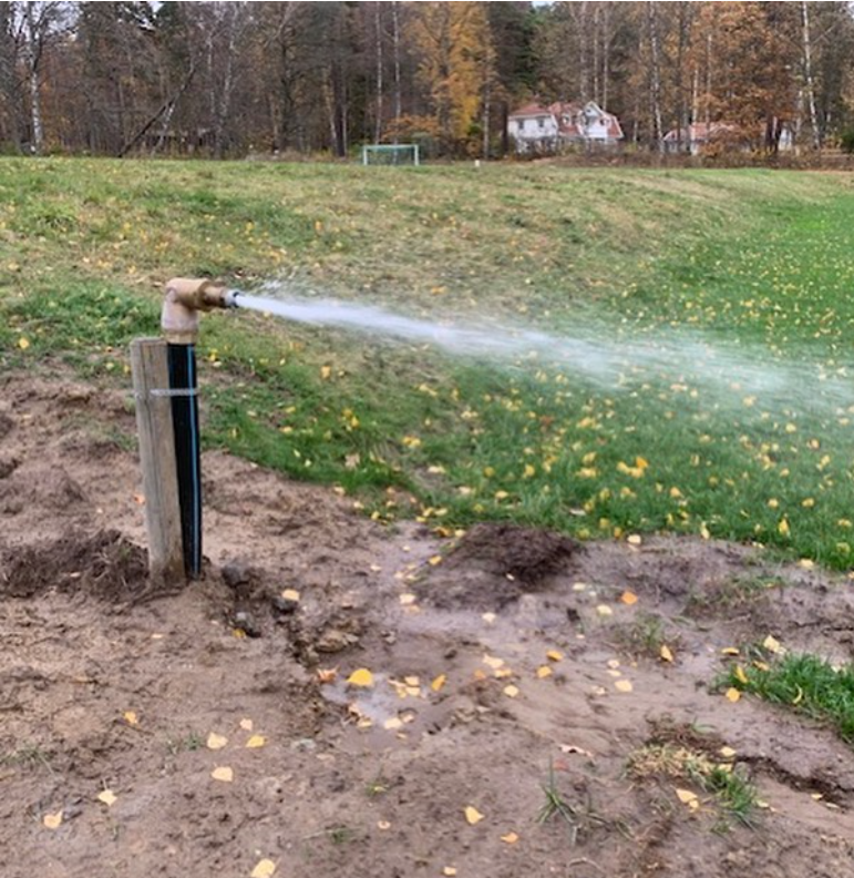 Vattenpost p&aring; fotbollsplan som sprutar vatten