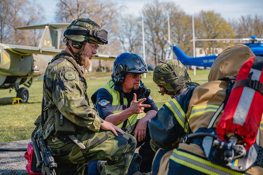 Militärer och helikopterförare överlägger, övning Aurora 23 foto Kristoffer Olofsson Försvarsmakten