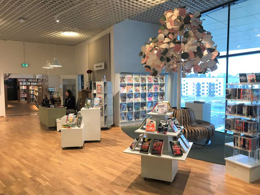 Interiör i Gränbystadens bibliotek med bokhyllor och en stor lampa