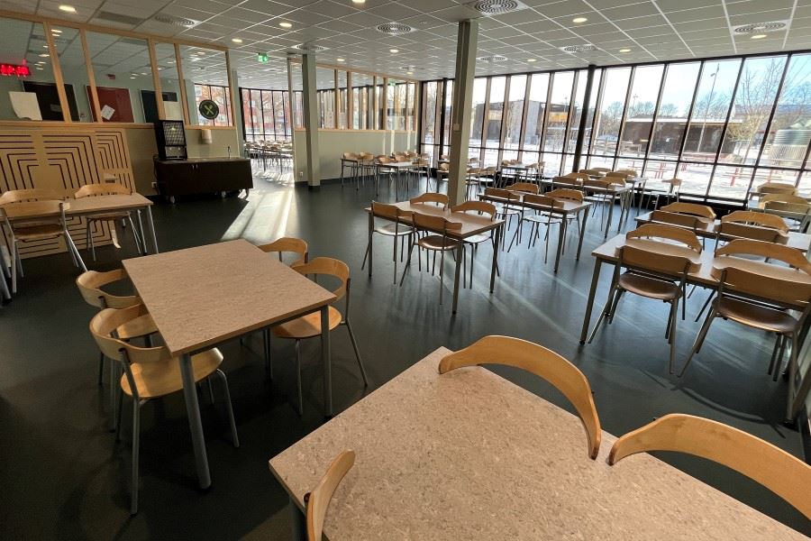 Skolmatssal med bord och stora fönster