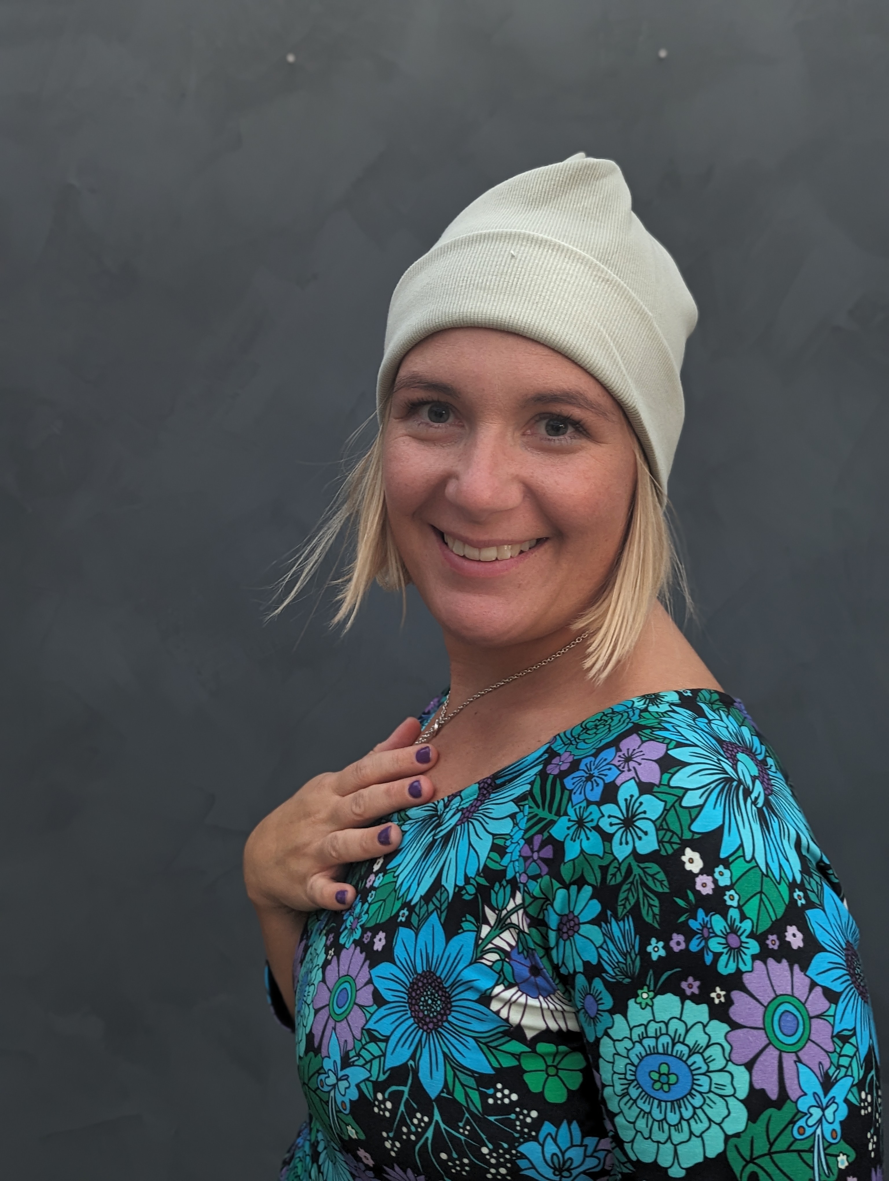 Kvinna med en vit mössa som ler.
