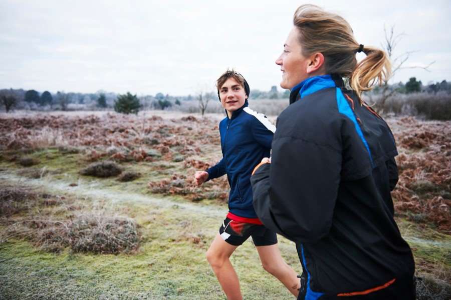 En medelålders kvinna som joggar med en tonåring