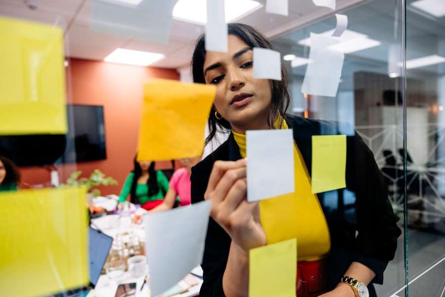 Kvinna som skriver på en post-it