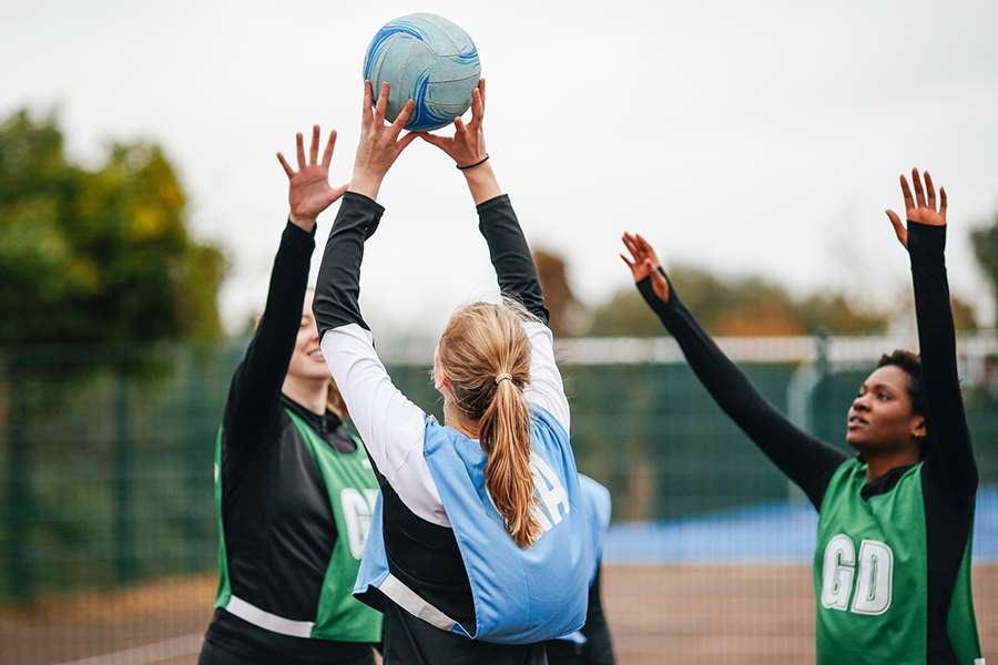 Ungdomar spelar volleyboll utomhus.