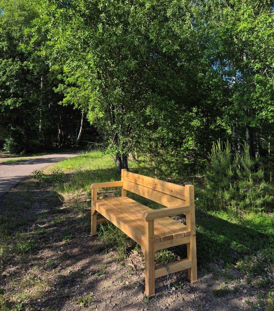 Sittbänk i trä i skogen i Björklinge.