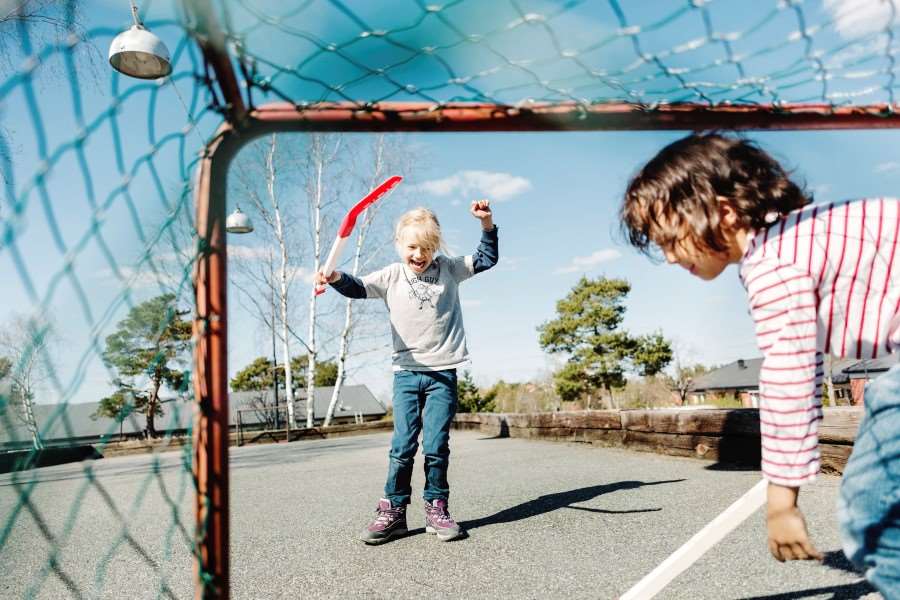 Två barn som spelar innebandy.
