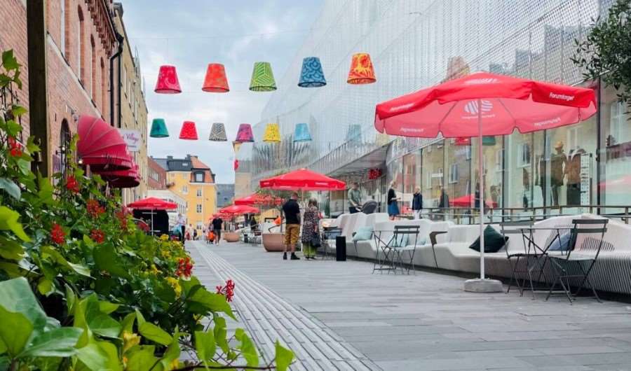 22 stora färgglada lampskärmar som hänger mellan två byggnader