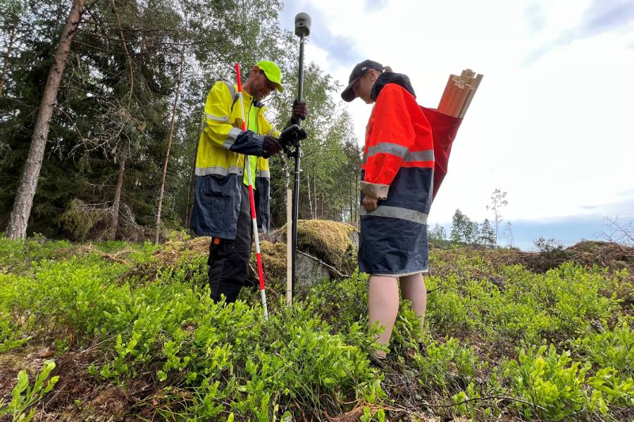 Två personer gör en lantmäteriförrättning