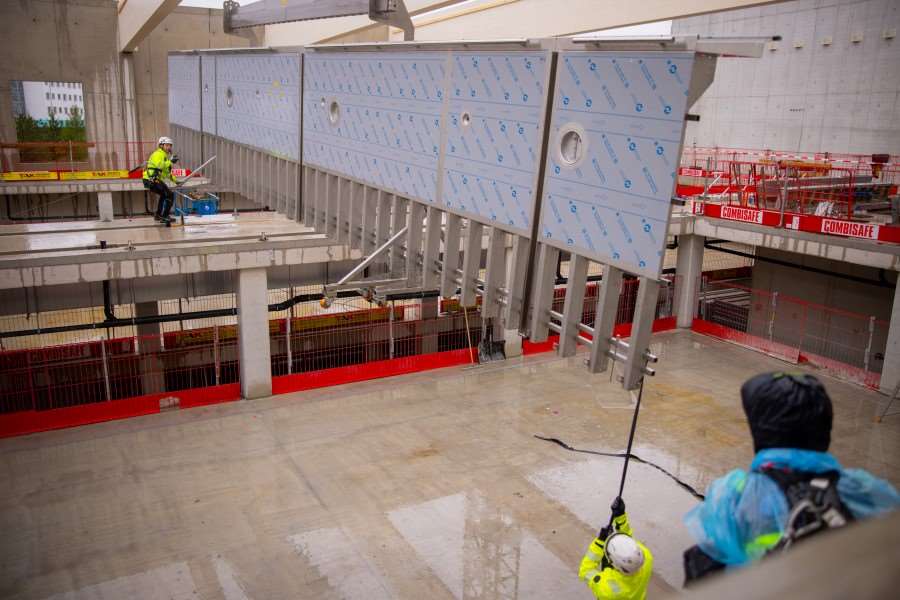 En rostfri bassängvägg lyfts in i nya Gränby simhall.