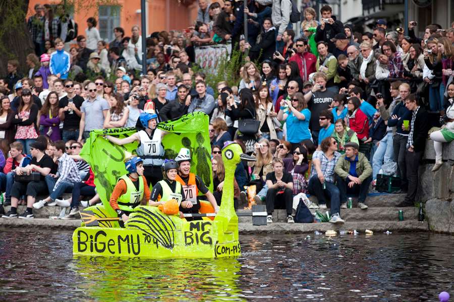 Forsränning under valborg i Uppsala. Ett flotte och mycket publik längs Fyrisån.