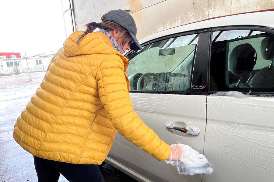 person tvättar bilen i en gör det själv hall