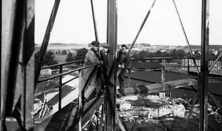 Svartvit bild på tre män i ett bygge