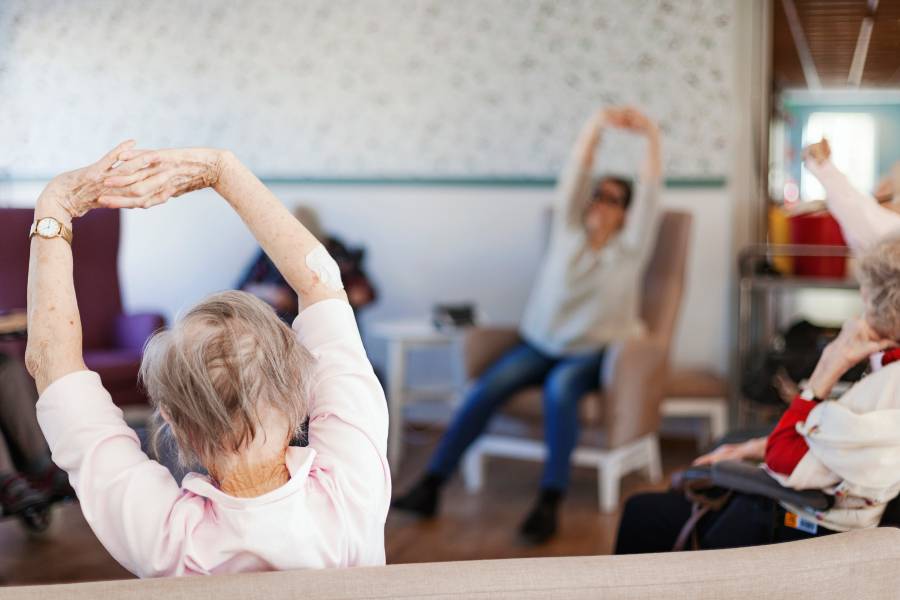 Äldre personer sitter och tränar i ring på ett äldreboende