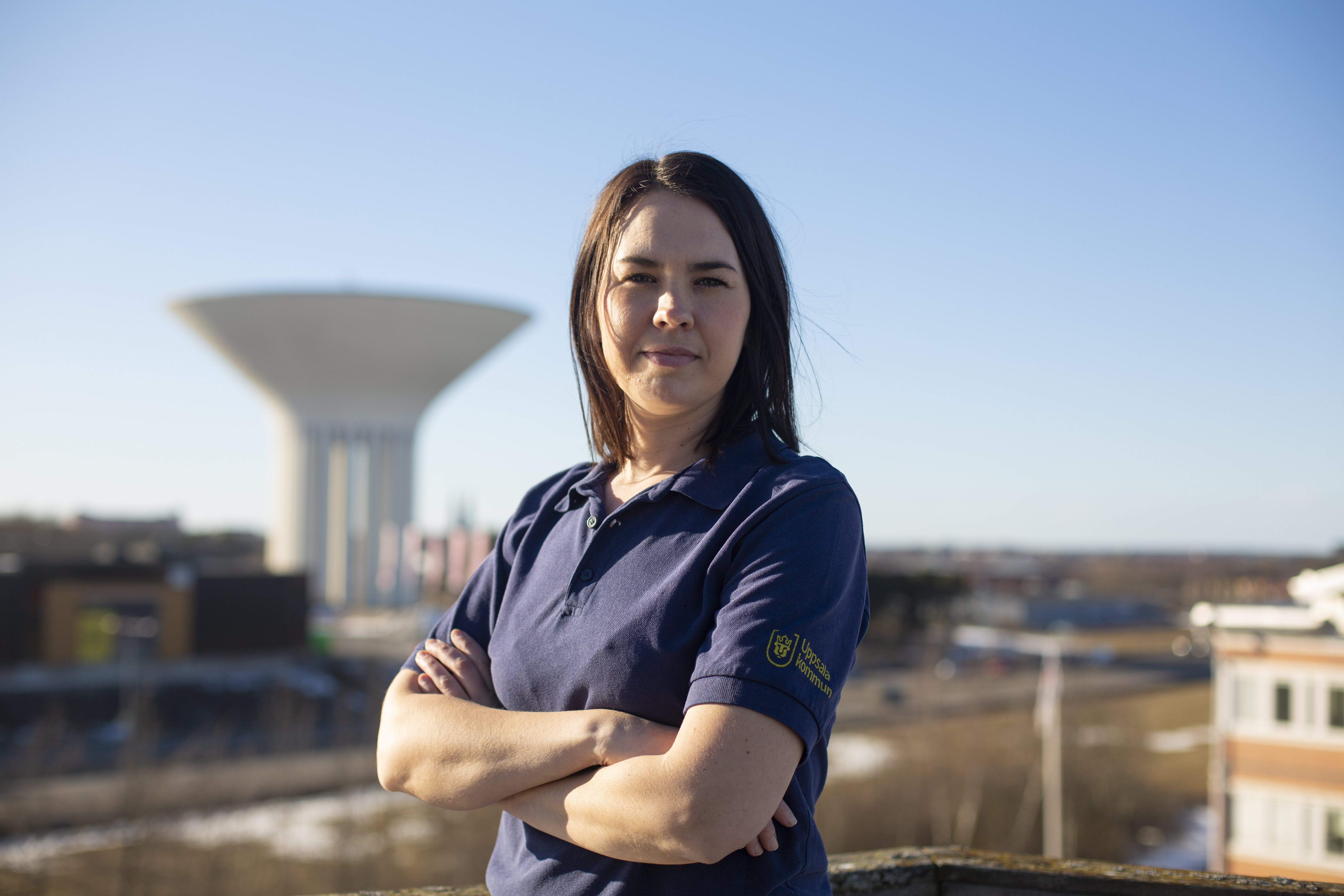 Kvinna på ett tag en solig dag. Uppsala vattentorn i bakgrunden