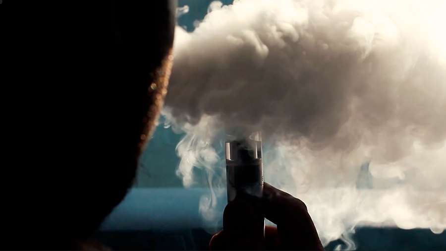En ung person röker en e-cigarett