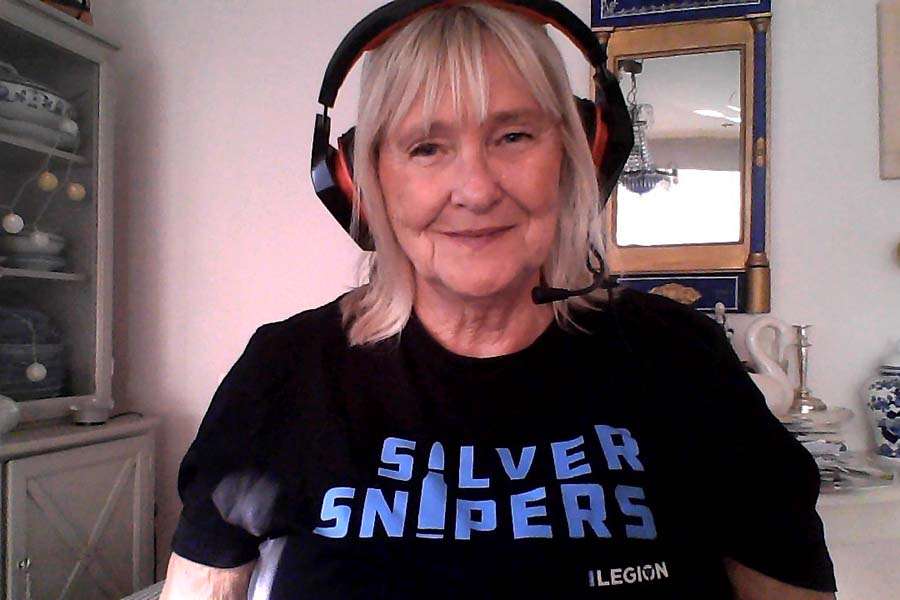 En kvinna med hörlurar och en t-shirt med texten Silver snipers