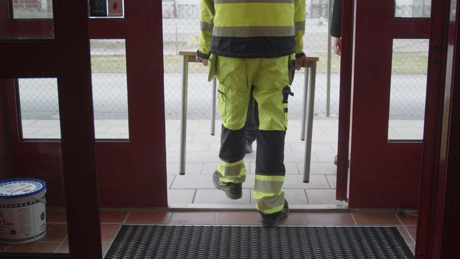 En person ber ut ett bord från ett hus