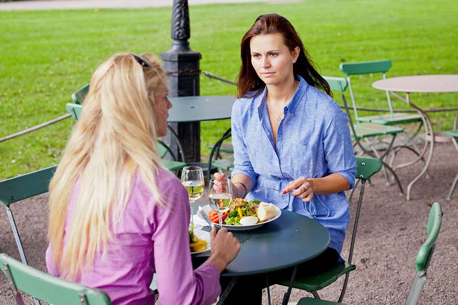 Två gäster äter lunch vid ett cafébord