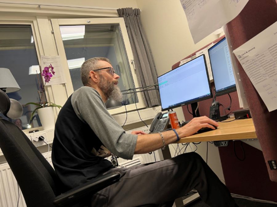 En man sitter i ett kontor framf&ouml;r en dator