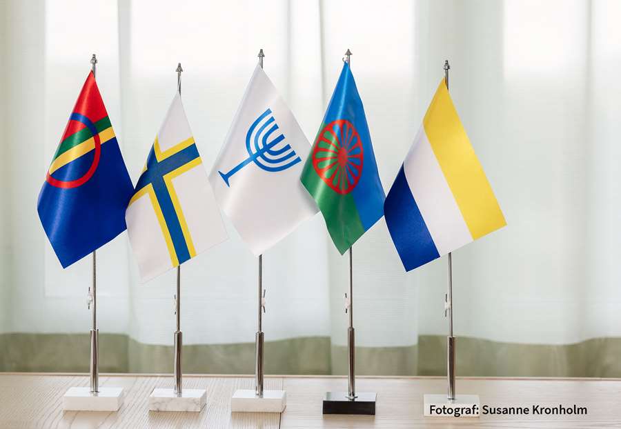 Fem bordsflaggor med symboler för respektive nationell minoritet