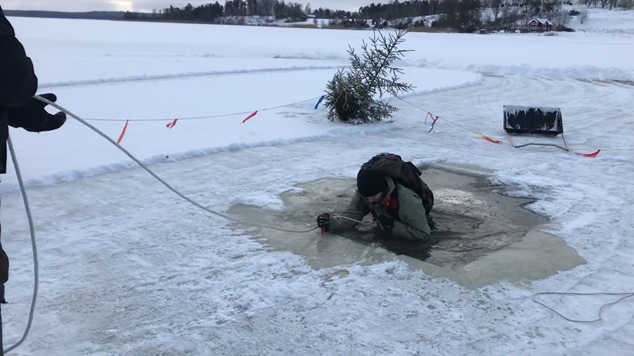 En person  tar sig upp efter att ha gått genom isen