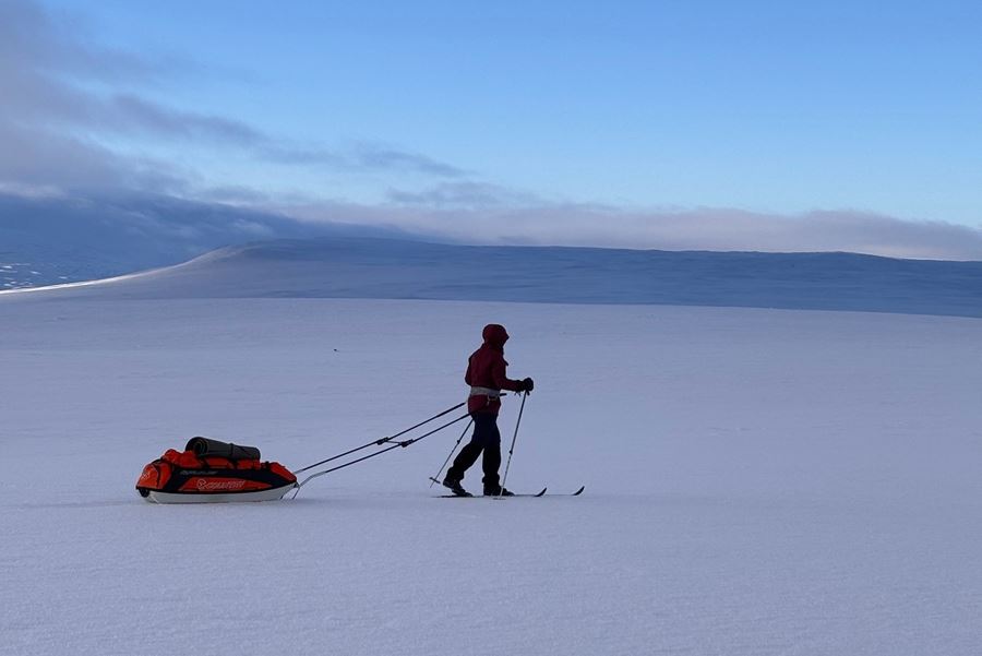 En person drar pulka på ländgsidor