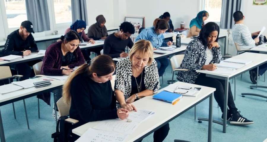 Ett klassrum med vuxna elever och en lärare