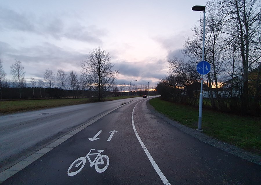 Separering genom en vitmålad linje och cykelsymboler med färdriktningspilar utmed cykeldelen