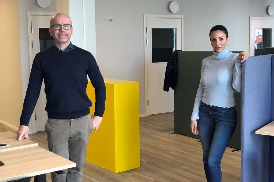 Man och kvinna står i ett kontorslandskap