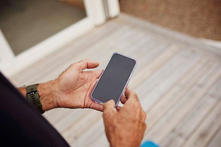 En hand håller i en mobiltelefon
