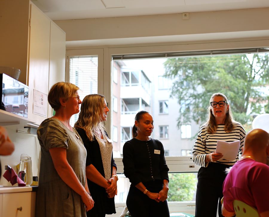 Fyra kvinnor står och pratar framför en grupp