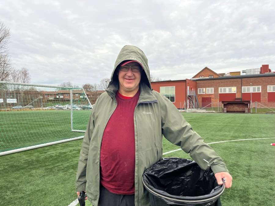 Jonas Andersson i omsorgsgruppen med städutrustning på en fotbollsplan