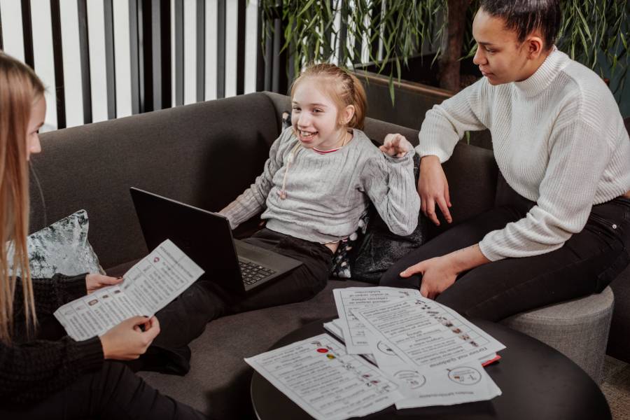 Glad flicka sitter i soffa och får hjälp med undervisning hemma