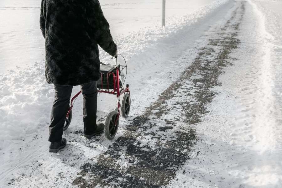 Dam med rullator på promenad