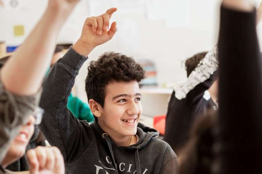 Kille räcker upp handen i skolan