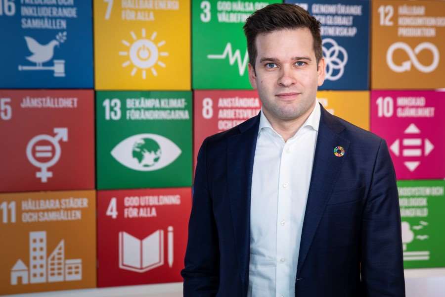 Portärttbild på abriel Wikström framför en fond med färgglada rutor som presenterar målen i Agenda 2030