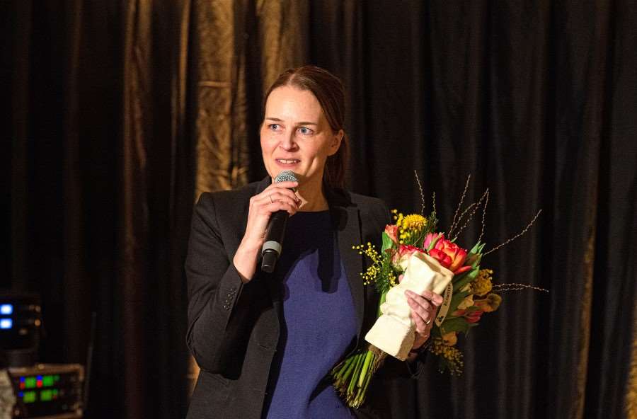 En person ser glad ut och håller i en blombukett