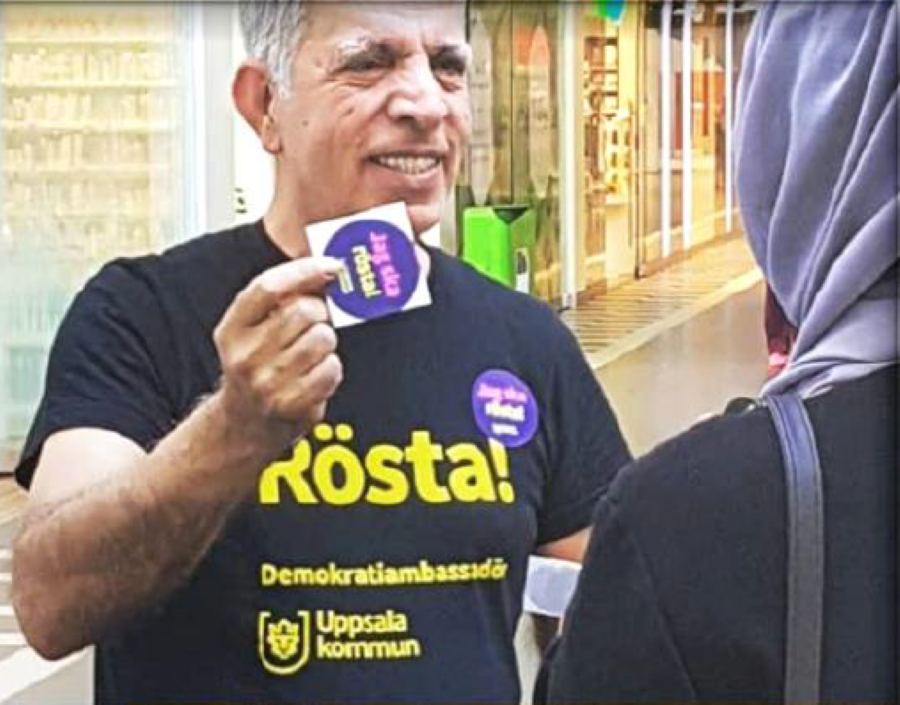 En person håller i ett klistermärke som det står "jag ska rösta" på.