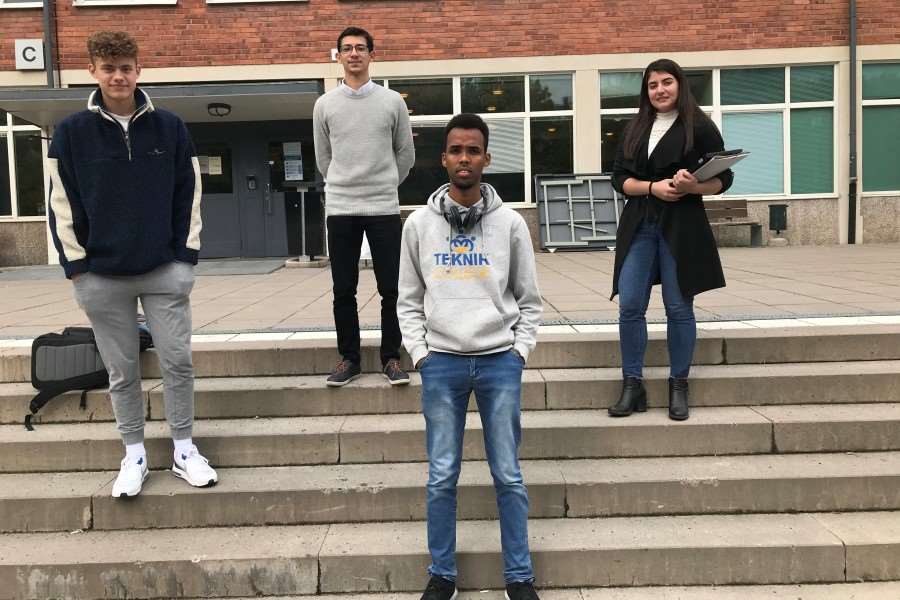 Fyra gymnasieelever på rad på en trappa