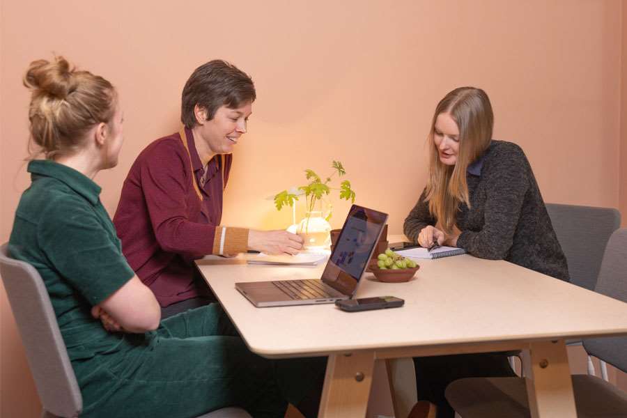 3 personer vid arbetar vid ett bord. Foto: Alex Giacomini, Lilla Produktionsbolaget.