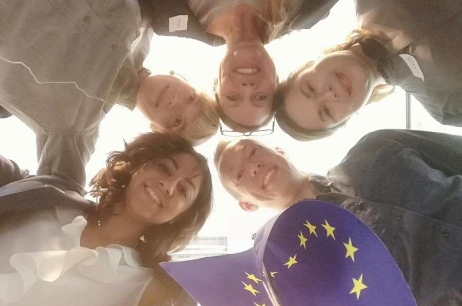 Fem personer med EUflagga tittar in i kameran.