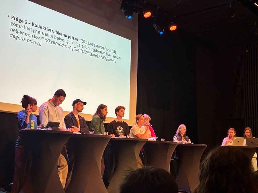 Ett gäng människor som sitter på en scen och debbatterar.