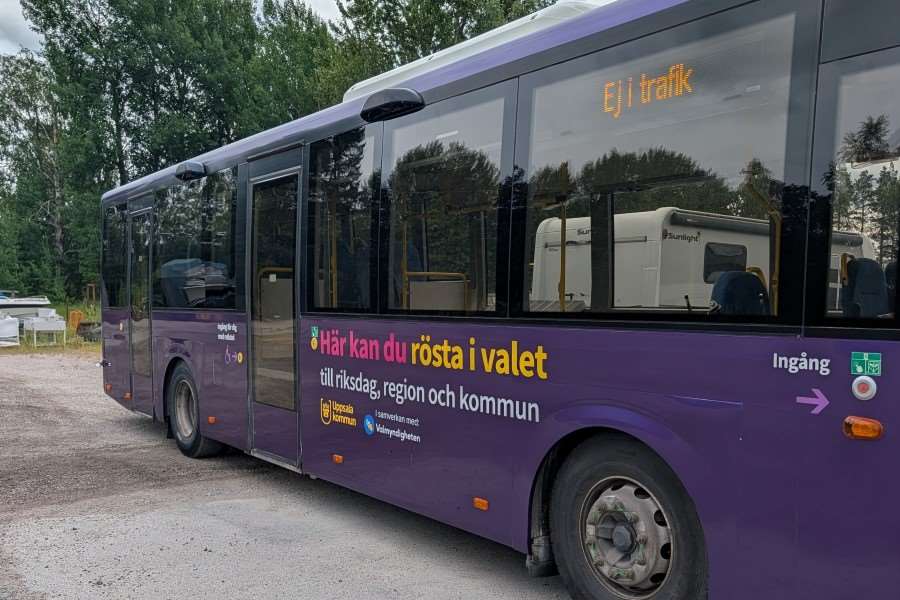 En lila buss som det står "Här kan du rösta" på