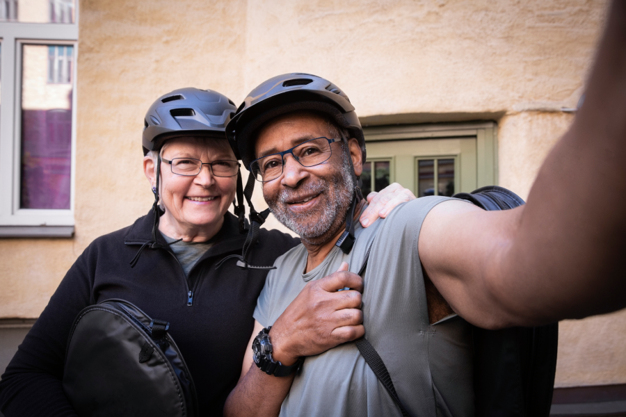 en man och en kvinna i cykelhjälmar tar en selfie