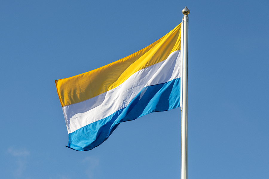 Tornedalingarnas flagga vajar mot en blå himmel