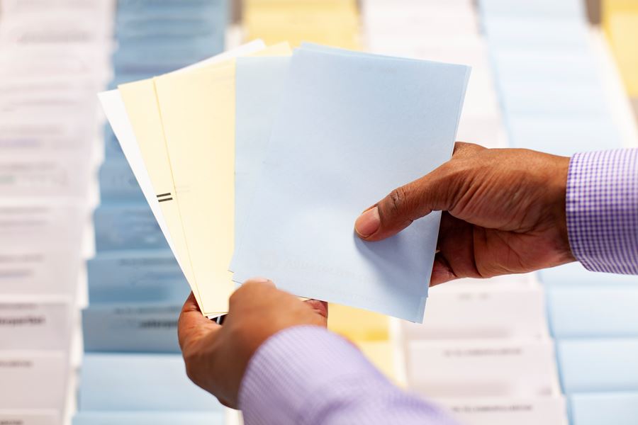 Händer som håller i valsedlar