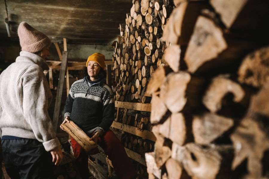 Två kvinnor vid en vedstapel