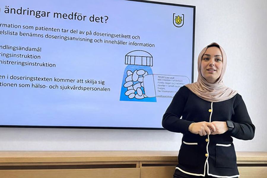 En kvinna står framför en powerpointpresentation