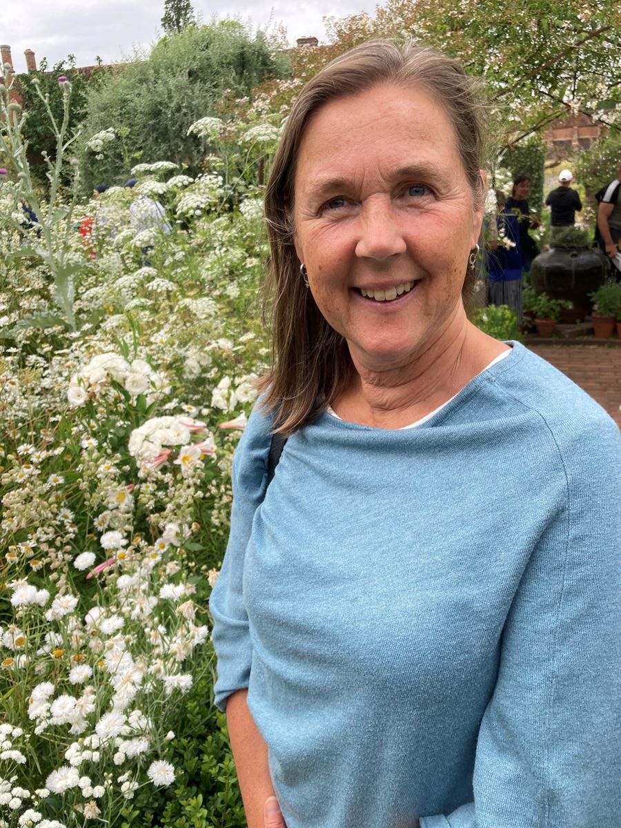 En kvinna står i grönska