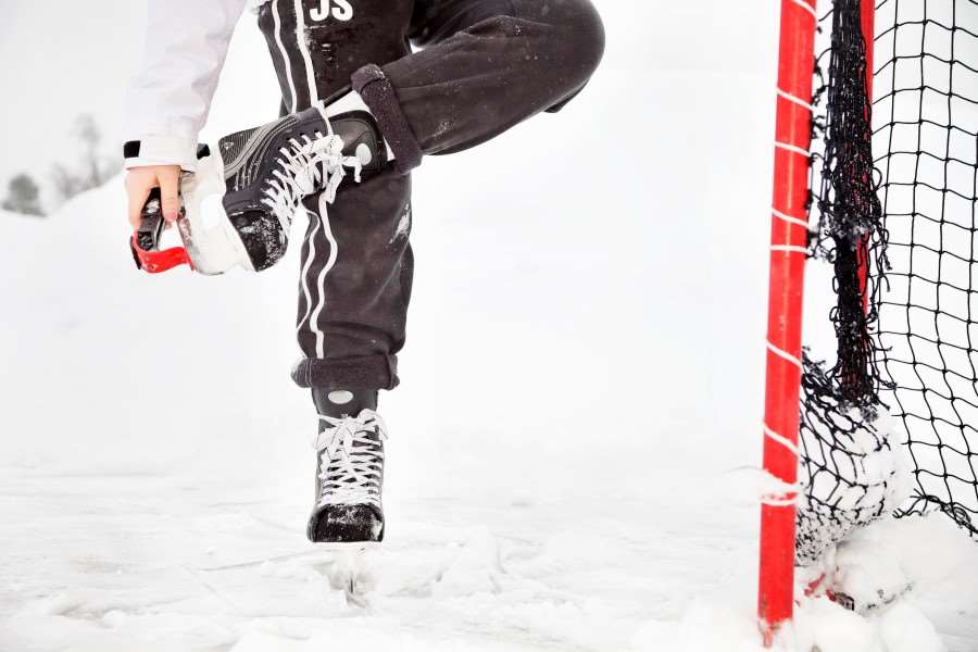 En hockeyspelare i skridskor vid ett hockeymål.